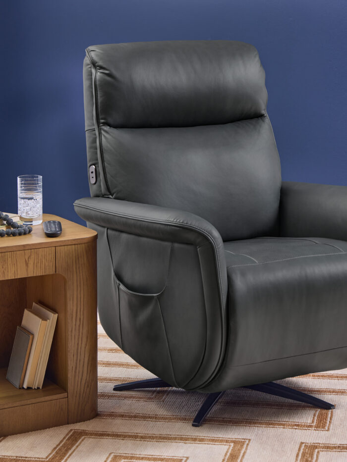 Flexsteel Haven leather power swivel recliner in Harbor leather shown upright beside a wood accent table
