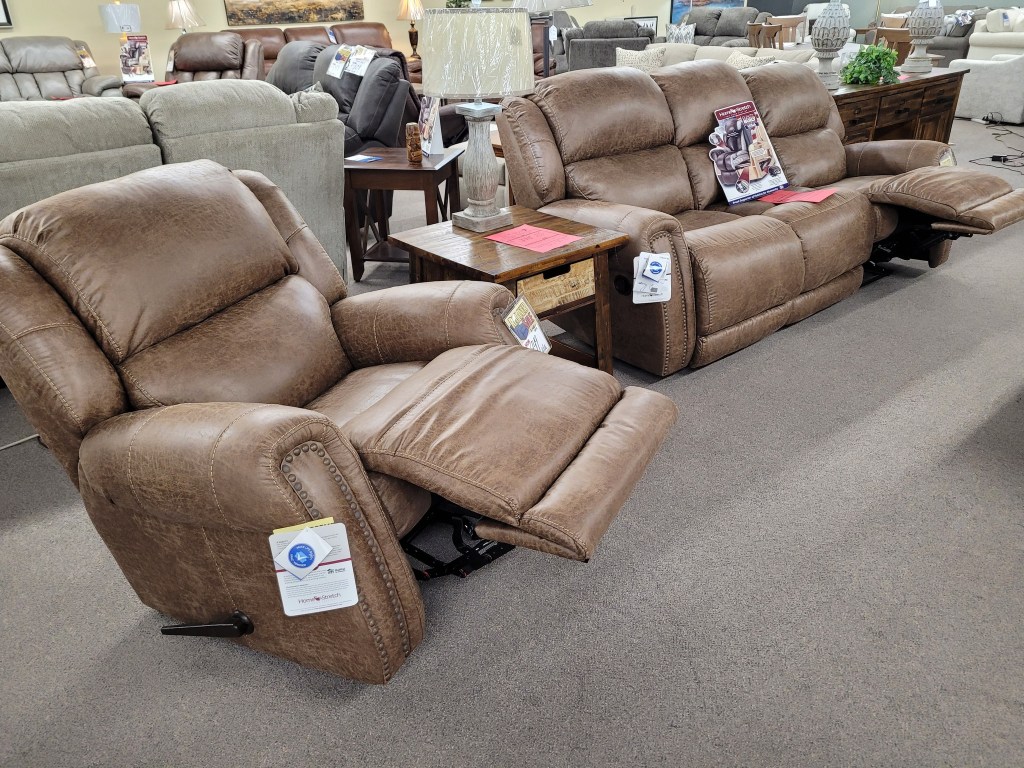 Matching Homestretch manual reclining sofa and rocker recliner in cozy fabric, shown as a two-piece living room set.