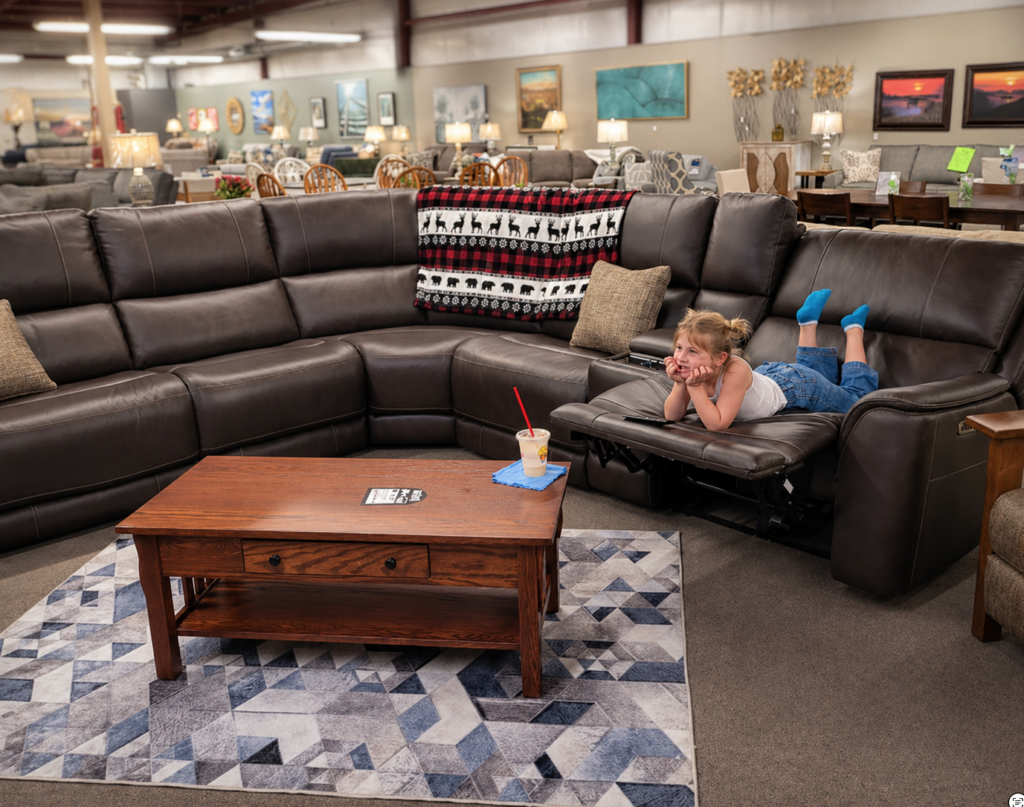 Sophie testing a Parker House leather 6-piece sectional on the showroom floor at Meyers Furniture in Mendota.