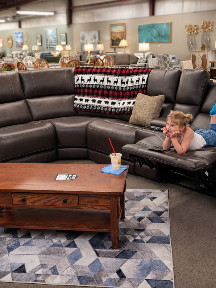 Sophie testing a Parker House leather 6-piece sectional on the showroom floor at Meyers Furniture in Mendota.
