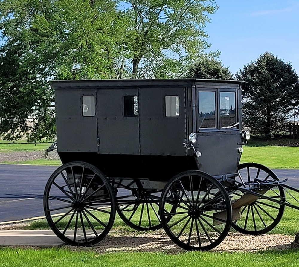 Black Amish buggy displayed outside Meyers Furniture & Flooring in Mendota