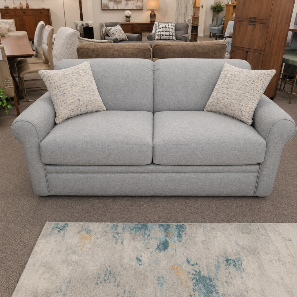 Light gray full sleeper sofa with two accent pillows on display at Meyers Furniture in Mendota.
