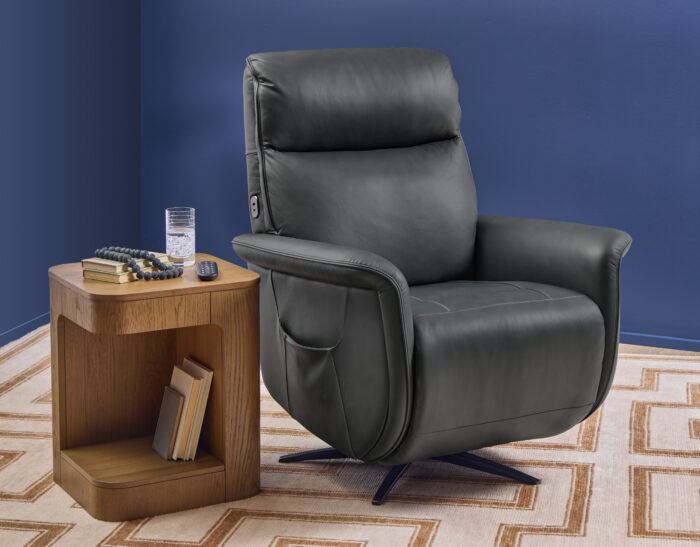 Flexsteel Haven leather power swivel recliner in Harbor leather shown upright beside a wood accent table