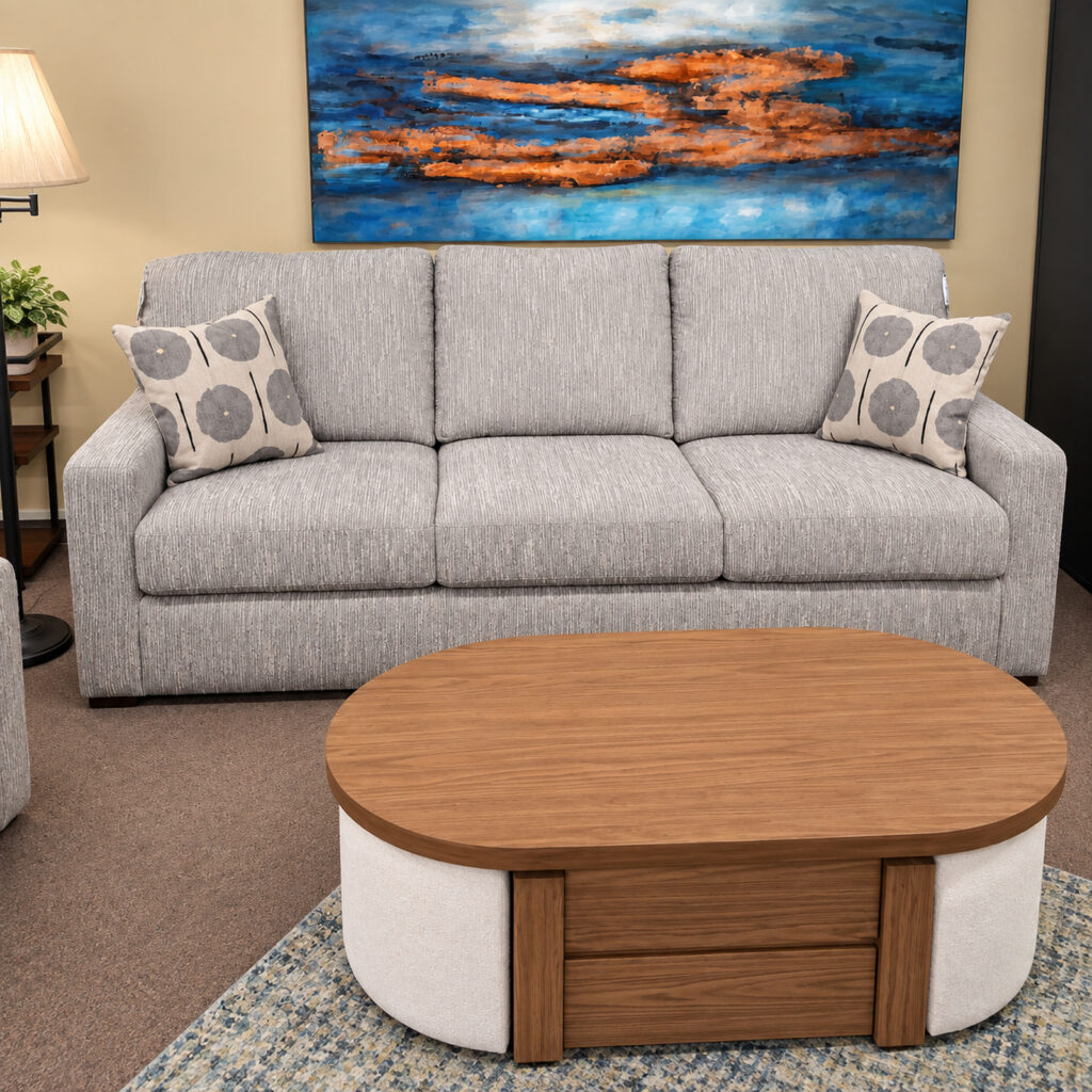 Light gray Best Home Furnishings sofa with three seat cushions and two patterned pillows.